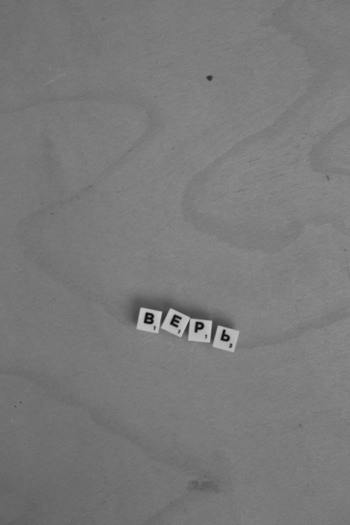 Black and white photo of Cyrillic letters forming верь on a wooden surface.